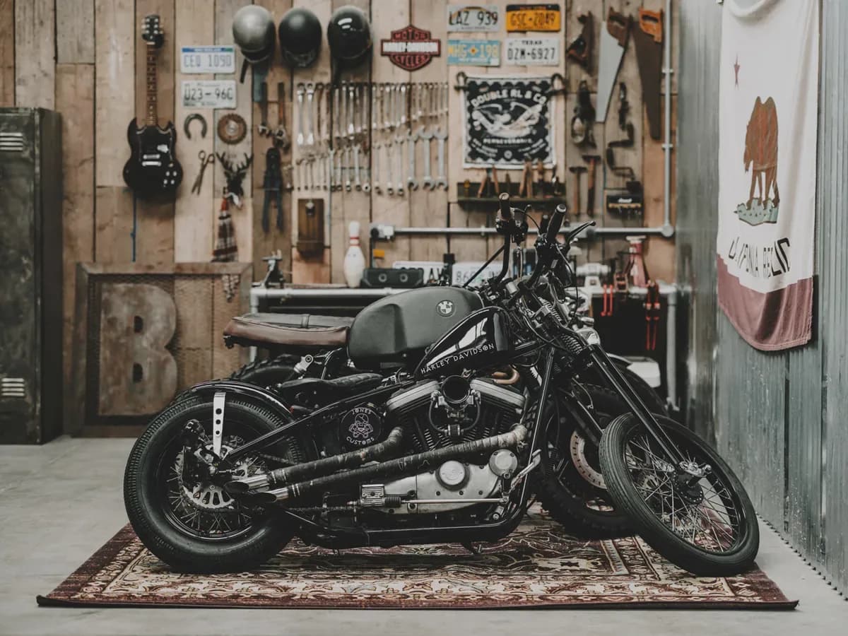 Custom motorcycle staged against the workshop wall in The Bailey