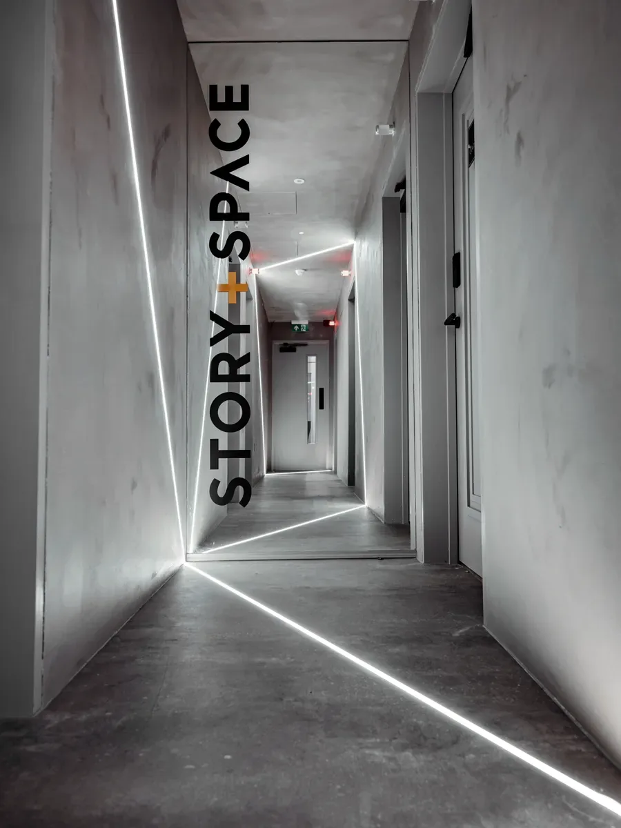 Story + Space name lit at the end of the concrete corridor