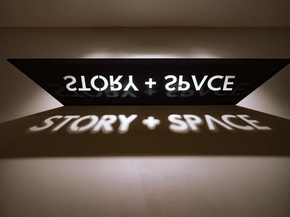 Story + Space logo projected in light above the stairwell