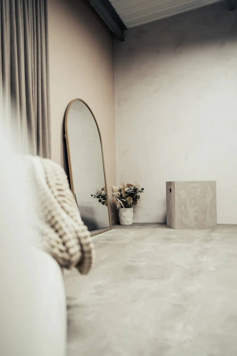 Gold-framed mirror and dried flowers in Cover Story