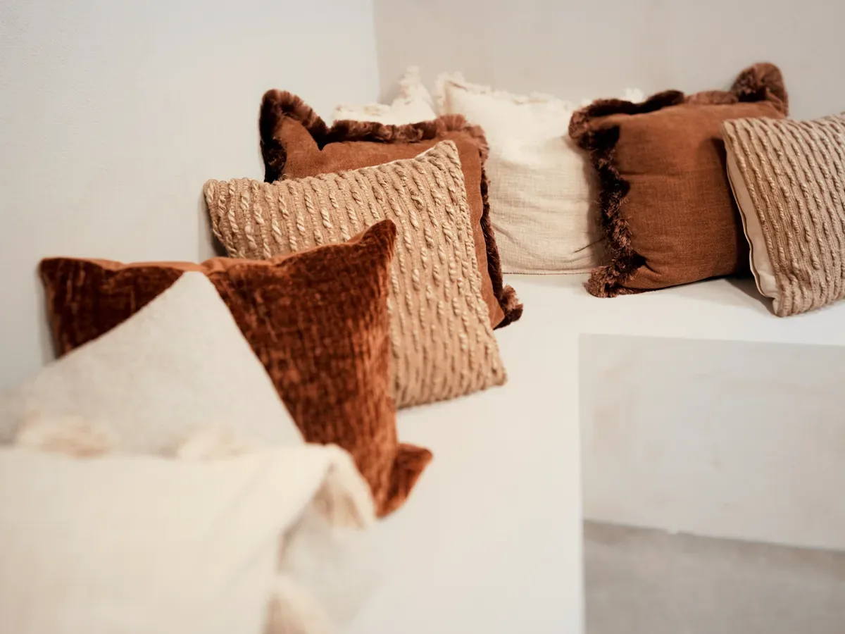 Rust velvet and cream textured cushion styling detail in Cover Story