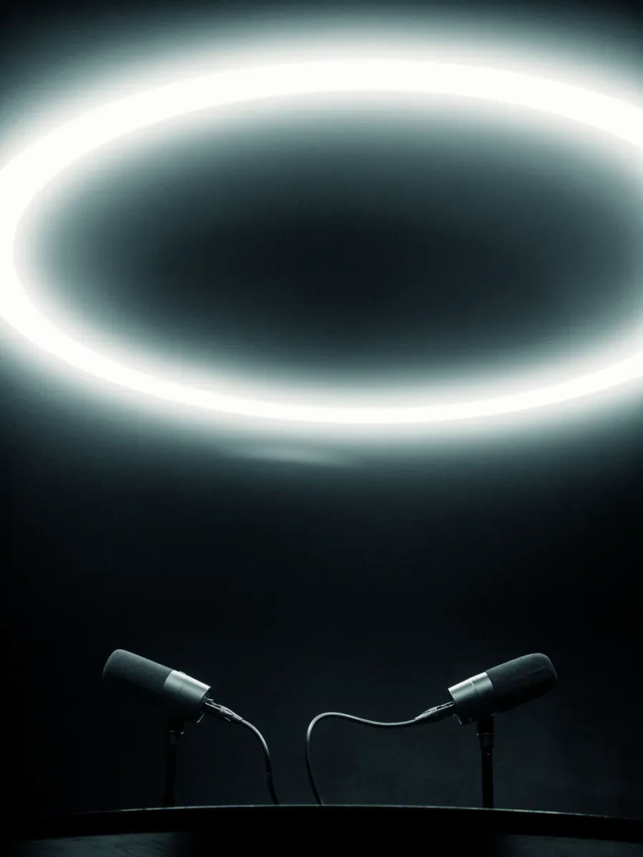Two microphones on the table beneath the halo ring light in The Round Table