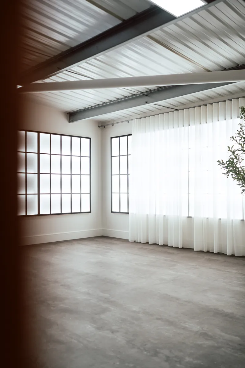 Crittall-style windows and sheer curtains flooding The Loft with natural light